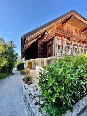 a large wooden house with a balcony on a street at Aparthotel Gaja in Bled