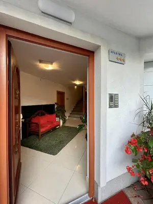a door leading into a room with a red couch at Aparthotel Gaja in Bled