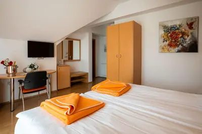 a bedroom with a bed with orange towels on it at Penzion Kovac in Radovljica