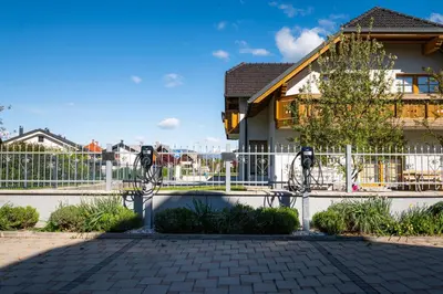 a building with a fence and two parking meters at Penzion Kovac in Radovljica