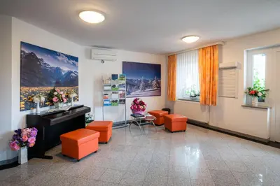 a waiting room with orange stools and a sink at Penzion Kovac in Radovljica