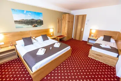 a hotel room with two beds in a room at Hotel Bau Maribor in Maribor