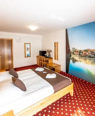 a hotel room with a bed and a view of a river at Hotel Bau Maribor in Maribor