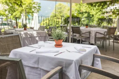 a table with white tablecloths and a plant on it at Hotel Lovec in Bled