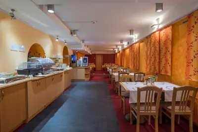 a restaurant with tables and chairs in a room at Hotel Tabor Maribor in Maribor