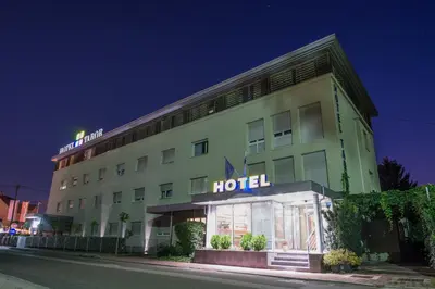 a hotel building with a sign on it at night at Hotel Tabor Maribor in Maribor