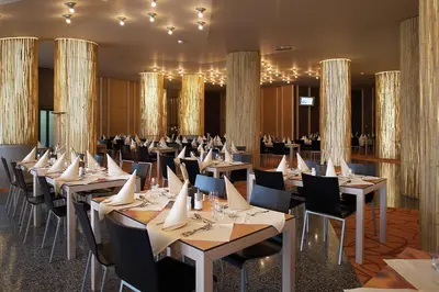 a dining room with tables and chairs and chandeliers at Terme Olimia - Hotel Sotelia in Podčetrtek