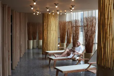 a woman sitting on a chair in a waiting room at Terme Olimia - Hotel Sotelia in Podčetrtek