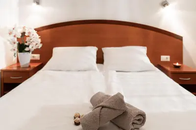 a stuffed animal is sitting on a bed at Hotel Medno in Ljubljana