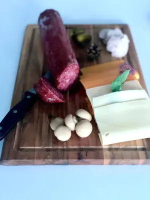 a cutting board with a knife and vegetables on it at Hotel Medno in Ljubljana