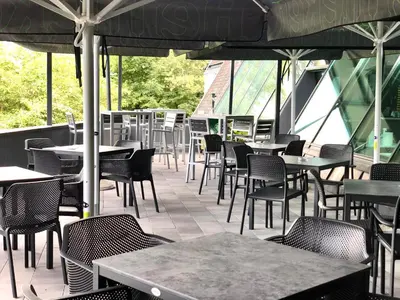 an empty restaurant with tables and chairs and windows at Hotel Medno in Ljubljana
