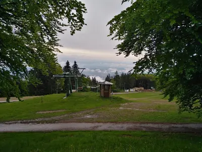 a park with a small building in the grass at Grand Hotel BELLEVUE in Pohorje