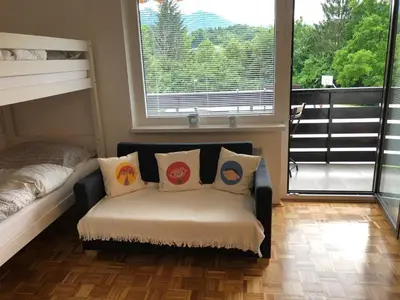 a room with a couch with pillows and a window at Apartma Vintage Bohinj in Bohinj