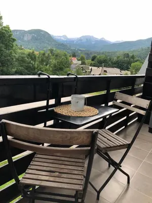 a table and chairs on a balcony with a coffee cup at Apartma Vintage Bohinj in Bohinj