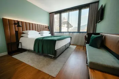 a hotel room with a bed and a couch at Hotel Astoria Superior in Bled