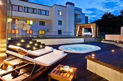 a backyard with a hot tub and a building at Hotel Astoria Superior in Bled