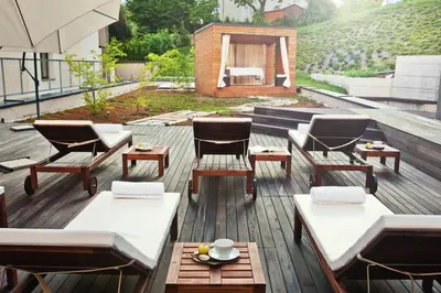 a patio with chairs and tables on a deck at Hotel Astoria Superior in Bled