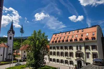 a building with a clock tower and a church at Hotel Kristal - Terme Krka in Dolenjske Toplice