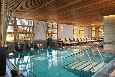 a large swimming pool with chairs in a building at Hotel Kristal - Terme Krka in Dolenjske Toplice