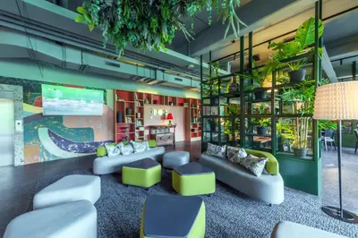 a living room with couches and plants at Hotel Sport - Terme Krka in Otočec