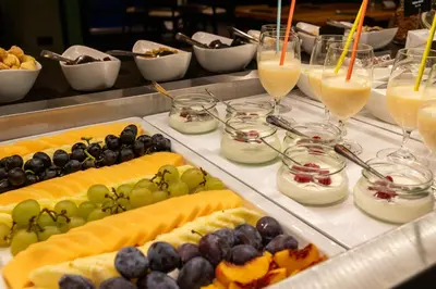 a buffet of food with fruit and glasses of juice at Hotel Sport - Terme Krka in Otočec