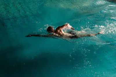 a man swimming on a surfboard in the water at Hotel Sport - Terme Krka in Otočec