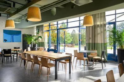 a restaurant with tables and chairs and large windows at Hotel Sport - Terme Krka in Otočec