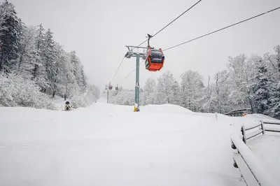 a ski lift in the snow with snow covered trees at Hotel Pohorje in Maribor