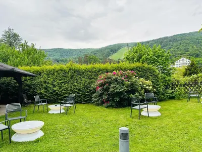 a group of chairs and tables in the grass at Hotel Pohorje in Maribor