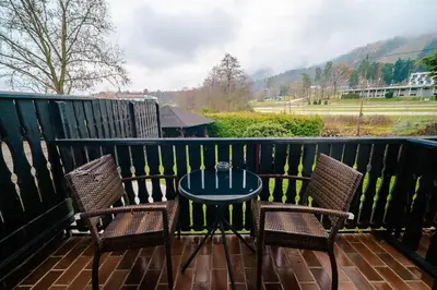 a patio with two chairs and a table on a balcony at Hotel Pohorje in Maribor