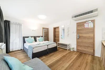 a bedroom with a bed with blue pillows at Hotel Pohorje in Maribor