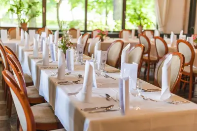 a row of tables with white table linens and chairs at Hotel Radin, Radenci Spa Resort - Sava Hotels & Resorts in Radenci