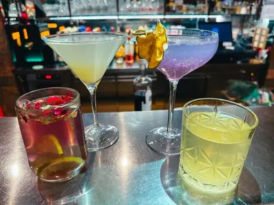 three cocktails sitting on a table in a bar at Hotel Oskar Zaplata in Preddvor
