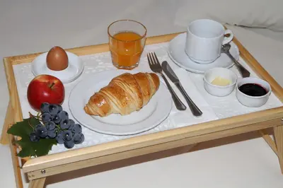a breakfast tray with a plate of croissant and fruit at Hotel Oskar Zaplata in Preddvor