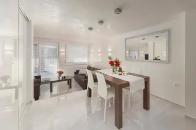 a dining room and living room with a table and chairs at Deluxe Apartma Jana in Ljubljana