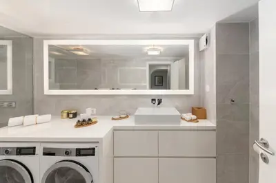 a bathroom with a sink and a washing machine at Deluxe Apartma Jana in Ljubljana