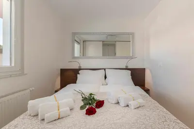 a bedroom with a bed with towels and a mirror at Deluxe Apartma Jana in Ljubljana