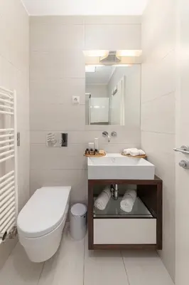 a white bathroom with a toilet and a sink at Deluxe Apartma Jana in Ljubljana