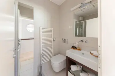 a white bathroom with a toilet and a sink at Deluxe Apartma Jana in Ljubljana