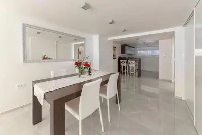 a kitchen and dining room with a table and chairs at Deluxe Apartma Jana in Ljubljana