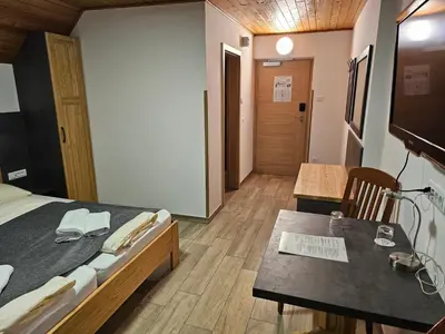 a bedroom with a bed and a table and a television at Hotel Gasperin Bohinj in Bohinj