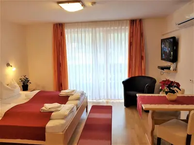 a hotel room with a bed and a chair at Hotel Gasperin Bohinj in Bohinj