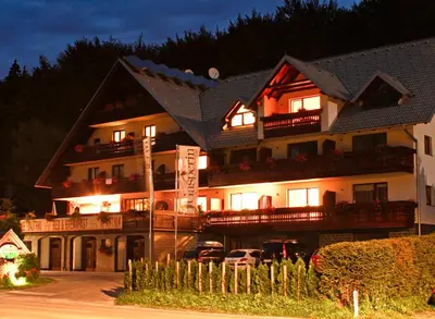 a large building with lights on in front of it at Hotel Gasperin Bohinj in Bohinj