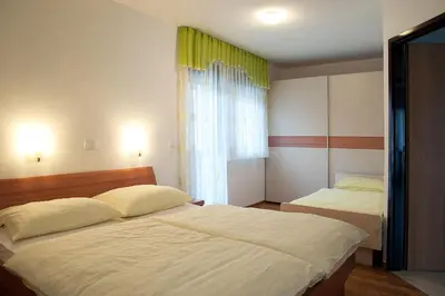 a bedroom with two beds and a window at Apartments Bohinj Mavrica in Bohinj