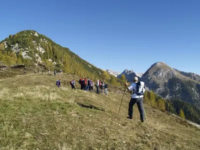 a group of people walking up a hill at Apartments Bohinj Mavrica in Bohinj