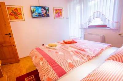 a bedroom with a bed with a striped comforter at Apartments Bohinj Mavrica in Bohinj
