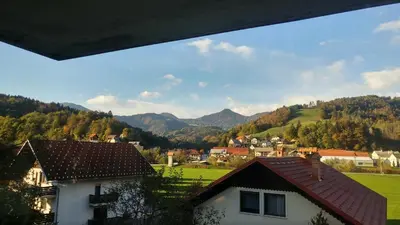 a view of a village with mountains in the background at Poldas apartments in Poljane nad Škofjo Loko