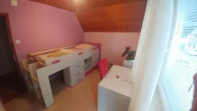 a small bedroom with a bed and a desk at Poldas apartments in Poljane nad Škofjo Loko