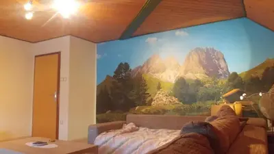 a bedroom with a mountain mural on the wall at Poldas apartments in Poljane nad Škofjo Loko