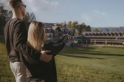 a man and a woman standing in a field at Hotel Arena Maribor in Maribor